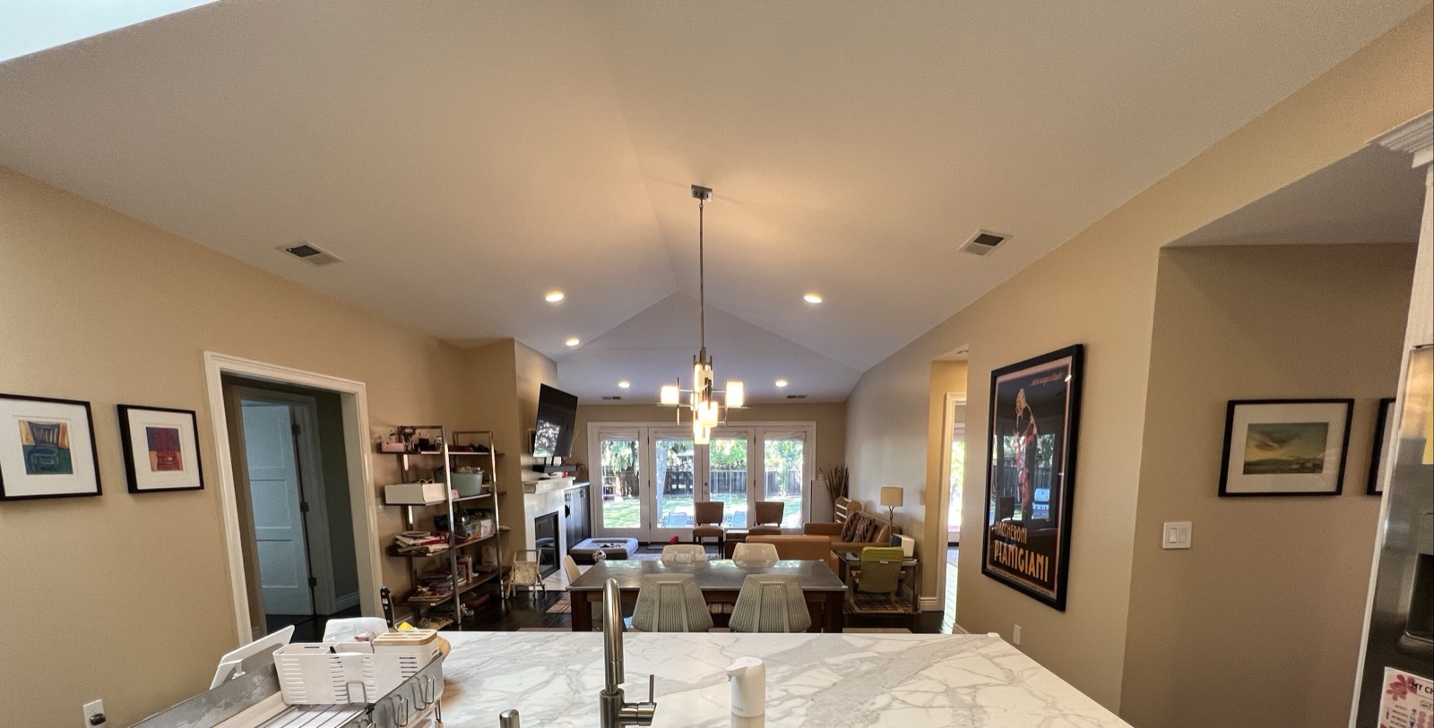 The Opal kitchen island and great room with the dining pendant and French doors beyond