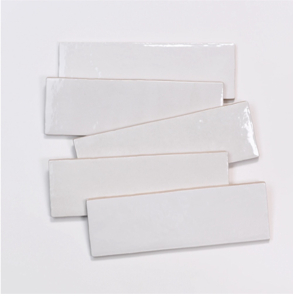 Five glossy white rectangular ceramic tile samples laid at angles